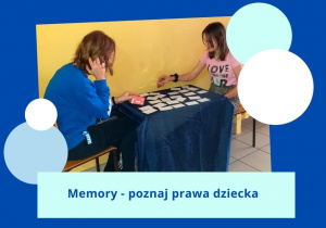 Uczennice siedzą przy stoliku w korytarzu szkolnym. Na stole rozłożone są karty do gry w memory. Uczennice układają pary takich samych obrazków.